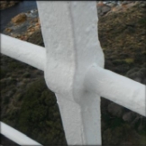 Photograph showing close up of white stanchion where railing is embedded. 