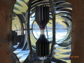 Photograph showing modern LED light source inside six panel lens. Prismatic glass can be seen surrounding the LED.