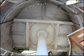 Photograph showing underside of round, white lantern floor. Beams and singular pole support floor.