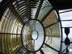 Photograph showing large, round lens comprised of glass prisms arranged in concentric circles.