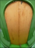 Photograph showing green pedestal base. Wooden doors are fitted into pedestal.