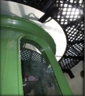 Photograph showing black lattice catwalk, wrapped around a green pedestal base. 