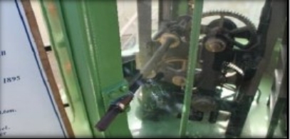 Photograph showing clockwork mechanism encased behind glass.