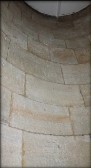 Photograph showing section of curved stone wall.