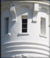 Photograph showing external face of round, white stone room with cornices and window ledges.