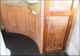 Photograph showing curved timber panels with timber door.