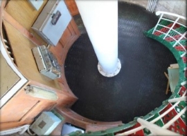 Photograph showing round room with spiral staircase and large white tube fixed in centre of room.