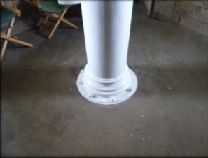 Photograph showing concrete slab with white tube fitted to centre of floor.