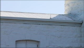 Photograph showing white, steel sheet roof of store room.