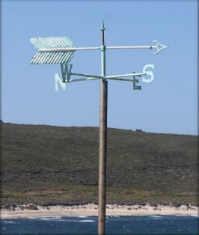 Photograph showing weathervane with arrow and direction pointers.