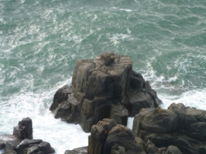 Photograph of rocks protruding from ocean. 