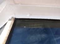 Photograph showing close up of clear glazing pane fitted into frame. 