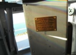 Photograph showing grey pedestal inside lantern room with Chance Brothers plaque fixed to it. 