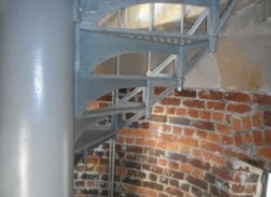 Photograph showing underside of grey lattice stairs. 