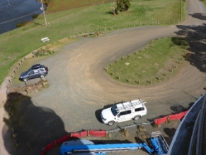 Photograph of dirt track road. Two cars are parked on the track. 