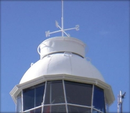 Photograph showing white lantern room roof with weathervane fixed at top.