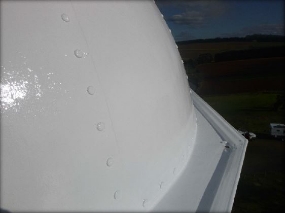 Photograph showing white lantern roof sheets and gutter edge.