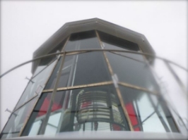 Photograph showing lantern room glazing panes arranged into three tiers. A prismatic lens can be seen sitting behind glazing.