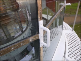 Photograph showing handhold fitted to glazing astragals of lantern room. Prismatic lens can be seen behind glazing panes.