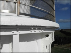 Photograph showing curved balcony floor bolted to brackets attached to tower wall. 