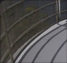 Photograph showing curved balcony balustrade and mesh fitted to outer edge of balcony floor. 