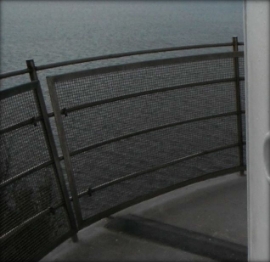 Photograph showing curved balcony balustrade and mesh fitted to outer edge of balcony floor. 