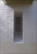 Photograph showing window and ledge set deep into painted brick wall. 