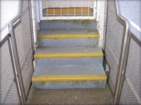 Photograph showing three grey steps at base of lighthouse tower entry door.