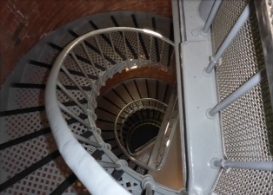 Photograph showing spiral staircase descending to lower floor landings inside lighthouse tower. 