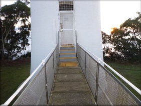 Photograph showing precast concrete slab bridge leading to upper lighthouse entry door.