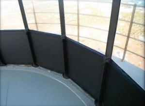 Photograph showing internal side of lantern house. Clear glazing panes are fitted above blank black panels. 