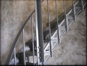 Photograph showing grey staircase fixed to stone wall