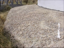 Photograph showing curved concrete apron paving at base of lighthouse tower.