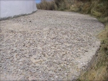 Photograph showing curved concrete apron paving at base of lighthouse tower.