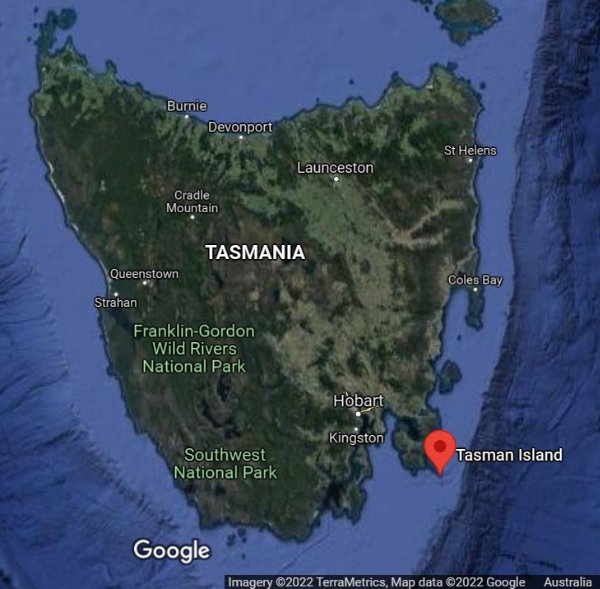 Satellite map showing Tasmania with some town and city names marked. A red location marker indicates location of Tasman Island off south-eastern coast. 