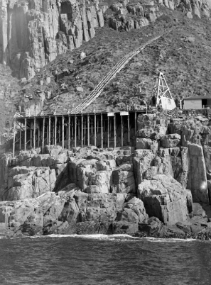 Black and white photograph showing the island's landing platform and a tramline leading up the steep cliff-edge. 