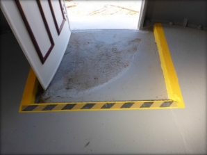 Photograph showing door entrance-way with hazard marking step. 