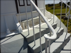 Photograph showing railing of stairs leading to base of tower door. 