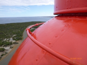 Photograph showing curved red dome roof of lighthouse tower.