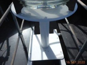 Photograph showing steel pedestal fitted to lantern room floor with prismatic lens sitting atop.