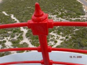 Photograph showing red balcony stanchion with railings fitted to it. 