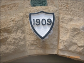 Photograph showing date stone reading '1909' fitted above front door. A National Trust plaque is fitted above.