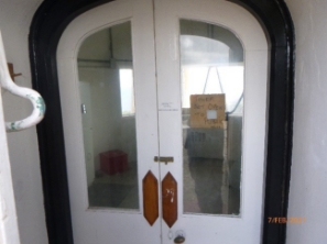 Photograph showing half-glazed, internal double doors inside lighthouse tower.