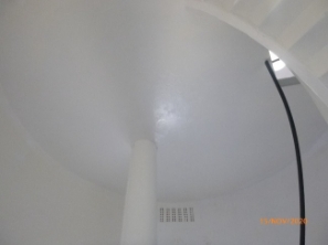 Photograph showing a weight tube fitted to the underside of a circular floor above. 