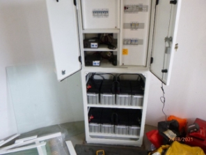 Photograph showing electrical cabinet and battery racks.