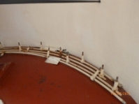 Photograph showing curved lantern room ladder rail resting on floor inside lighthouse tower.