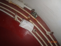 Photograph showing lantern room downpipes resting on floor inside lighthouse tower.