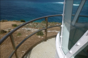 Photograph showing fibreglass mesh balcony with stainless steel railings curved around round lantern house. 