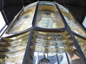 Photograph showing close up of prism pieces fitted into gunmetal framing of large lighthouse lens. 