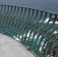 Photograph showing gunmetal balcony railing fixed to outer edge of balcony floor.